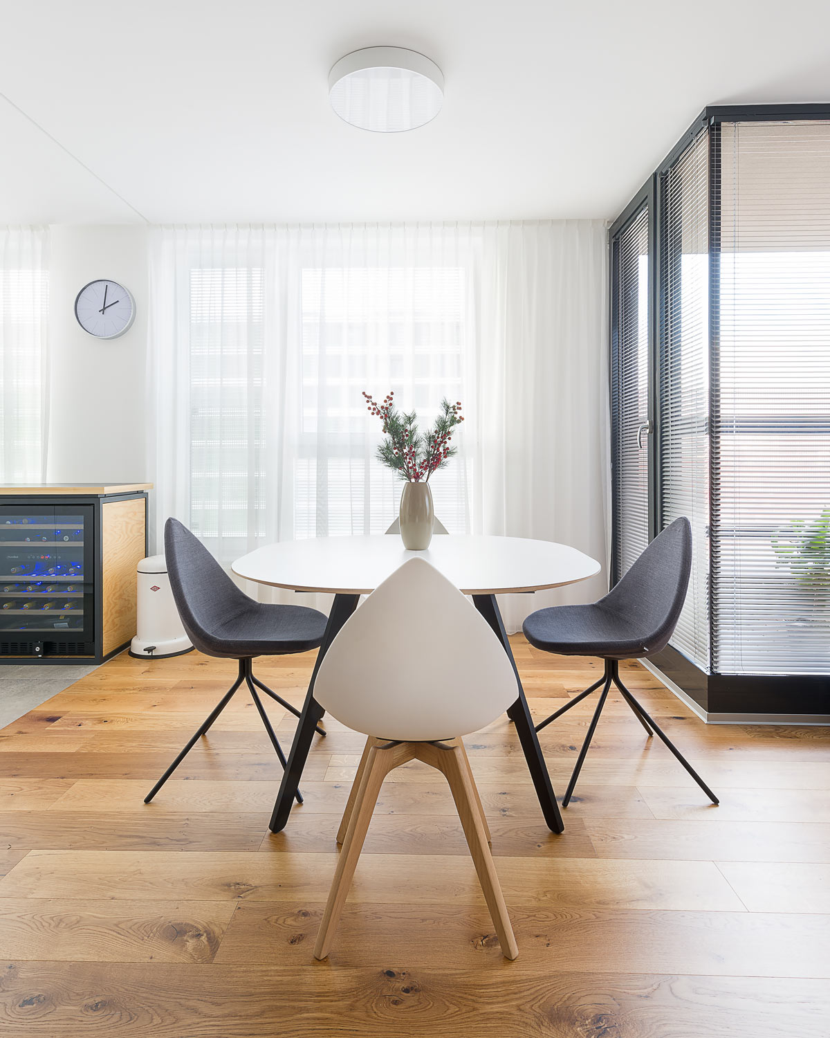Okrúhly jedálenský stôl, dizajnové stoličky BoConcept, dubová podlaha
